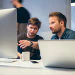 Two young men working together in office.