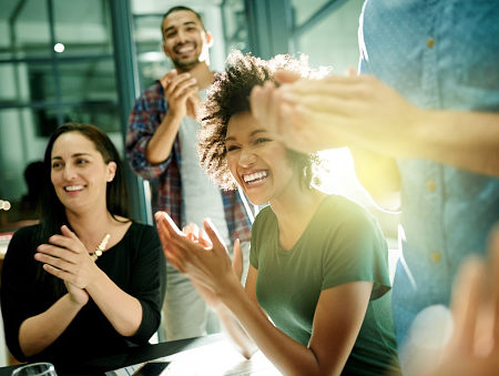 Shot of a team of creative businesspeople applauding an achievement while working late in the boardroom