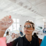 woman making plans on transparent glass