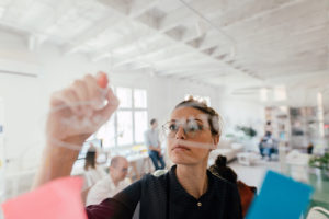 woman making plans on transparent glass